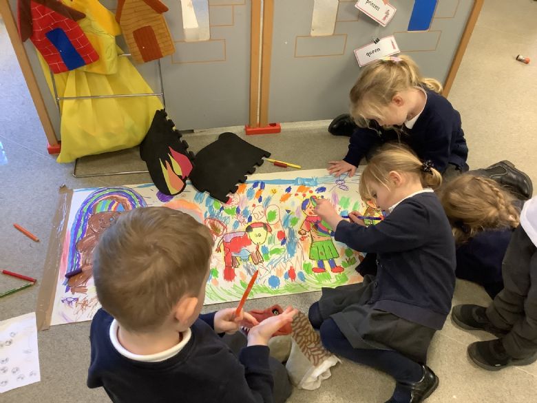A group of children collaborate on a large drawing.